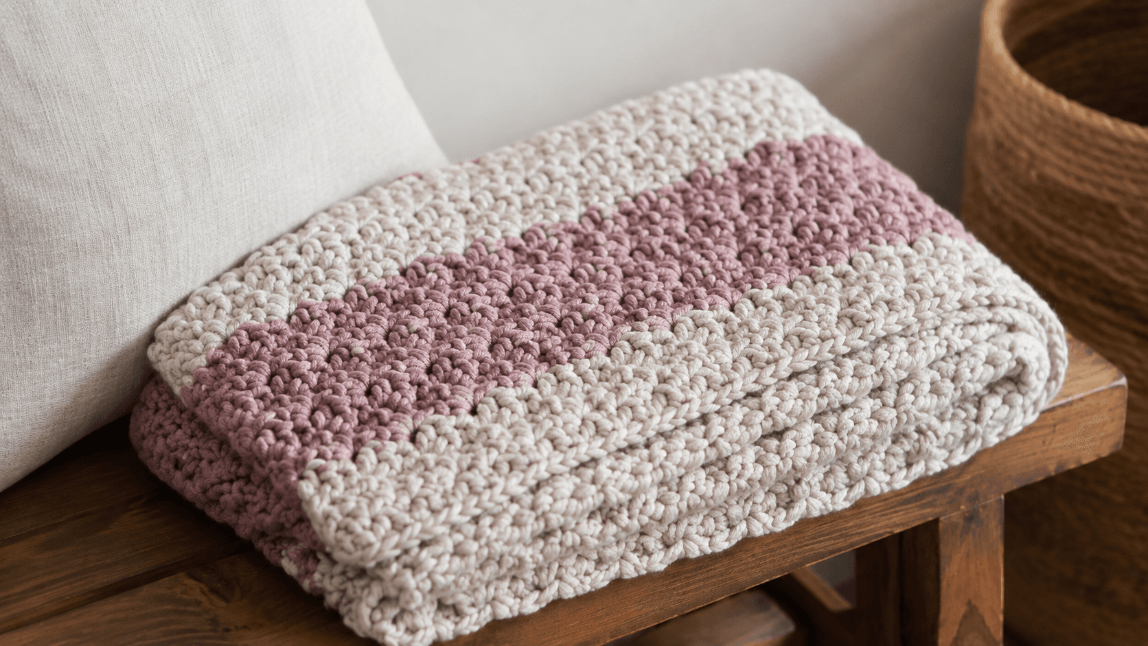 Folded pink and tan two-color chunky crochet throw blanket