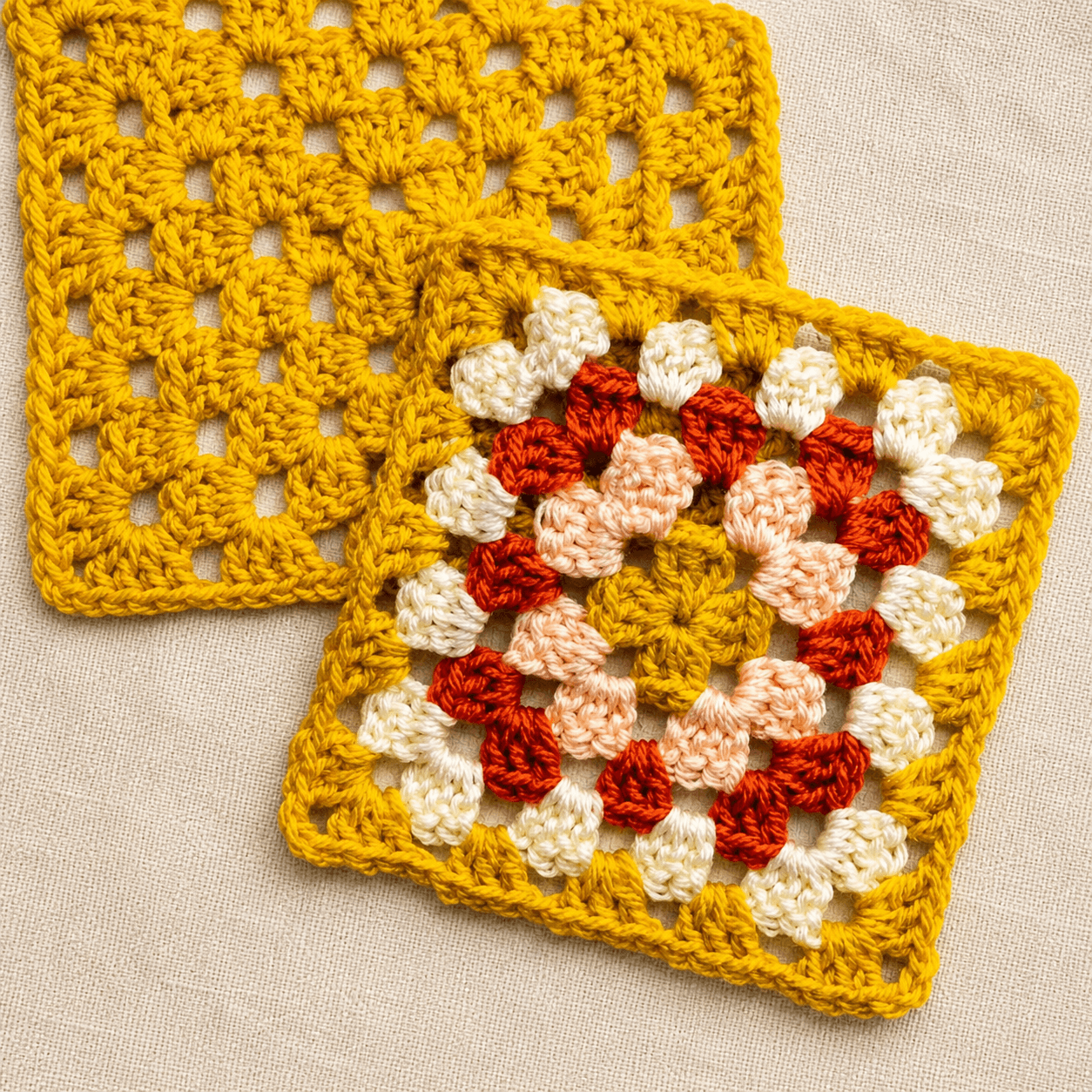 Mustard crochet granny squares, one plain and one with red, cream, and peach rounds