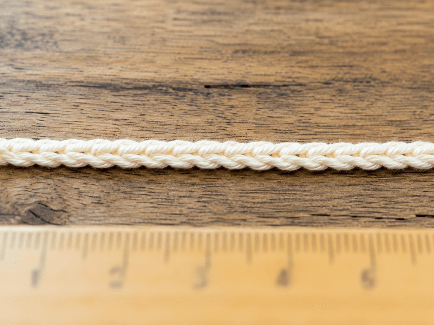 Crochet Foundation Chain Tutorial - detail shot: Top-down macro shot of a completed foundation chain laid flat in a stra