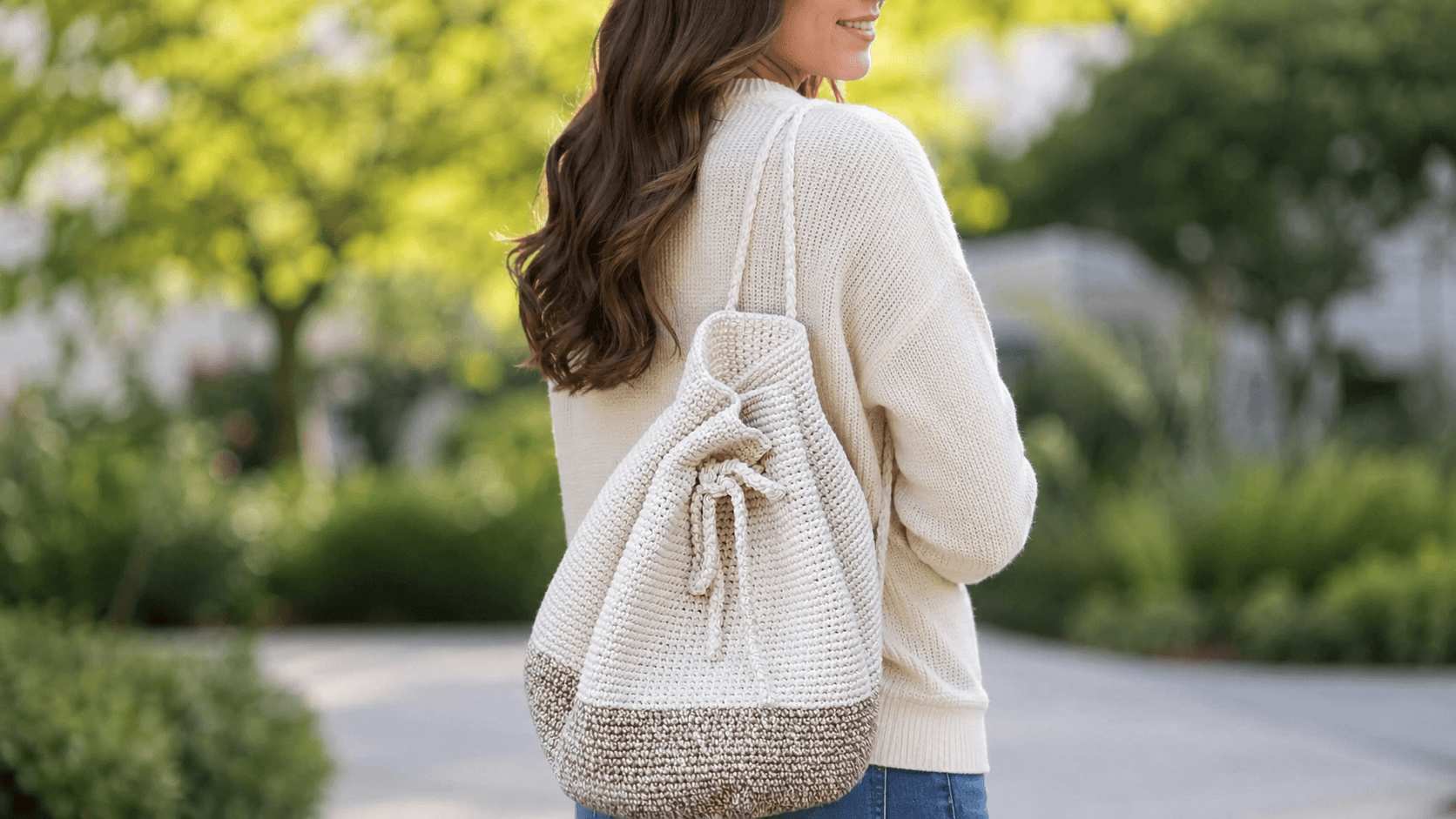 Cream and tan crochet drawstring backpack worn on the back