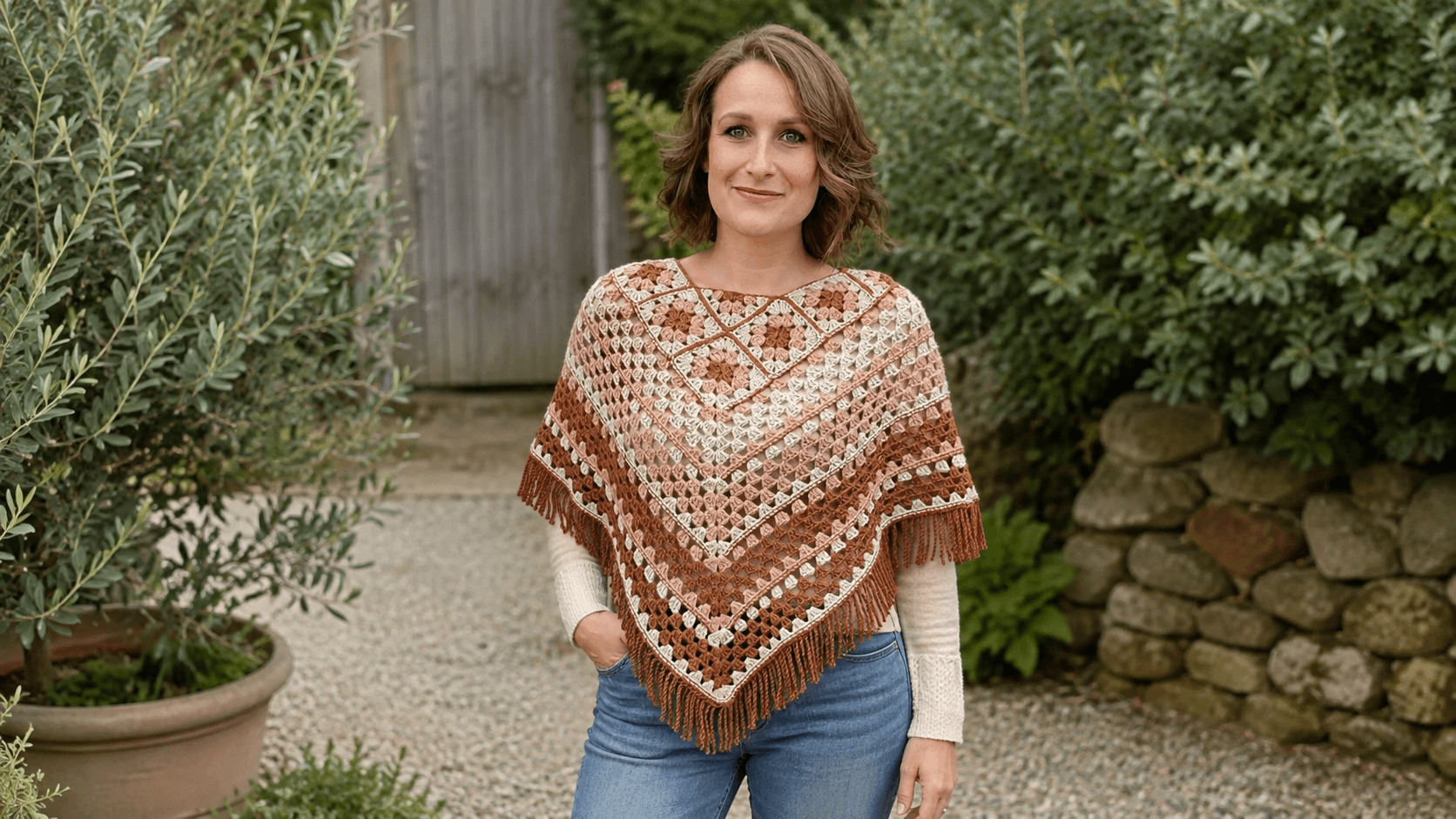 Rust and cream fringed granny square crochet poncho with sleeves