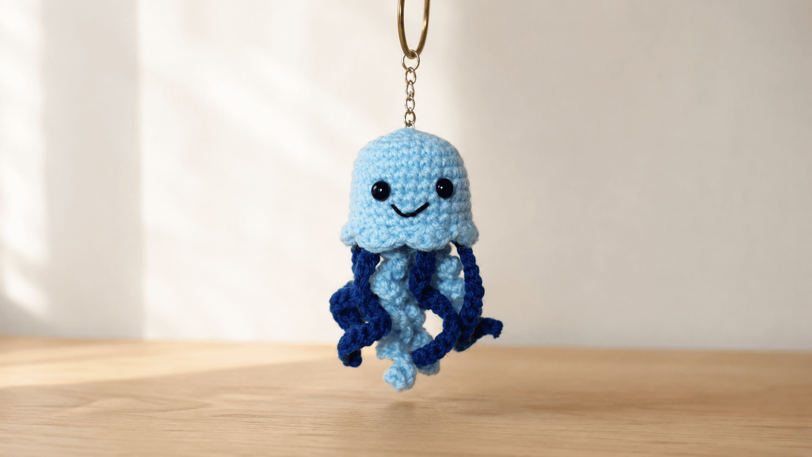 Light blue crochet jellyfish keychain on a keyring