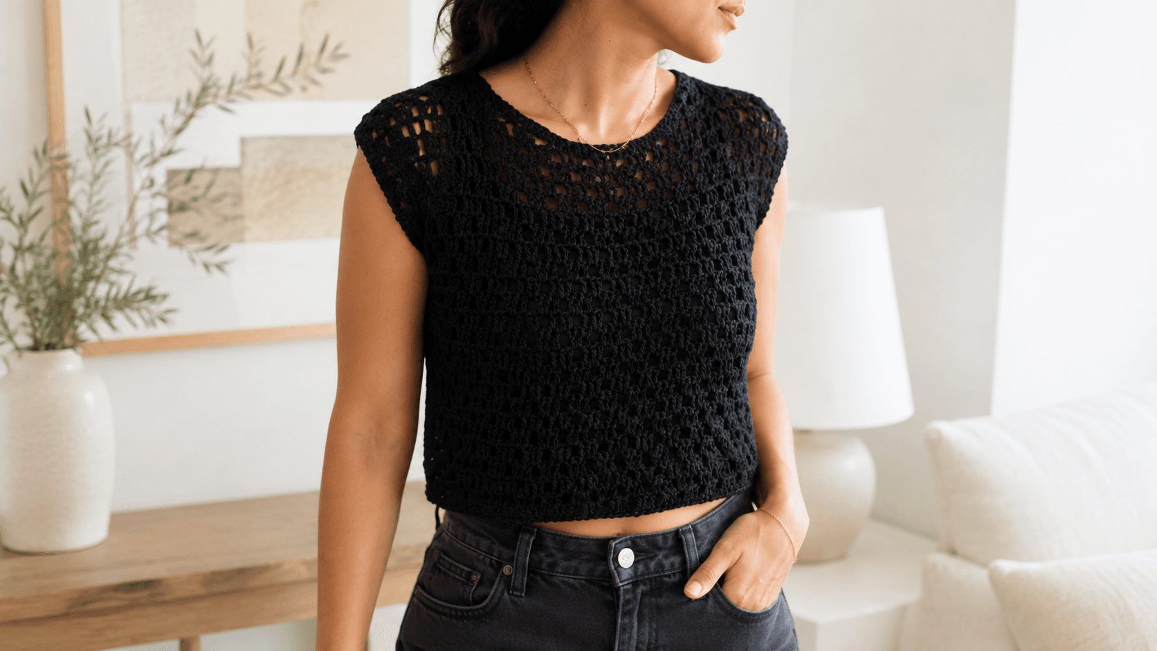 Woman wearing a black open mesh crochet crop top