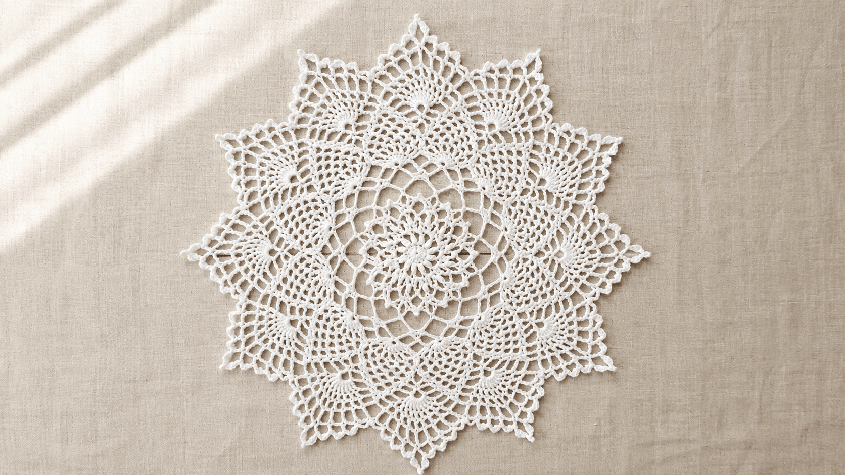 White star-shaped crochet doily with pineapple lace pattern