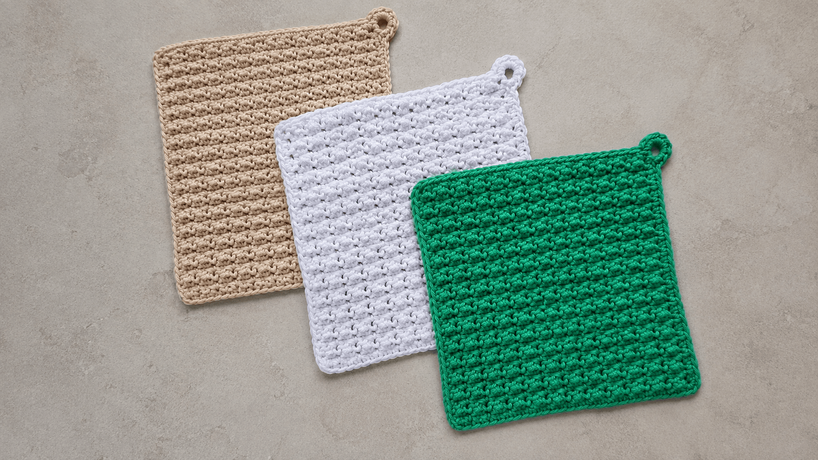 Tan, white, and green pebble-textured crochet washcloths with hanging loops