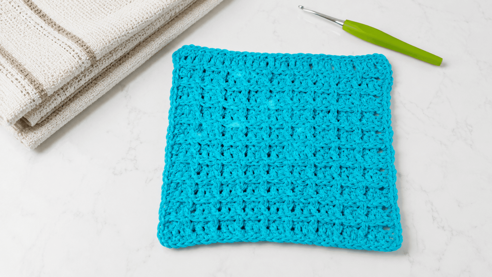 Teal waffle stitch crochet dishcloth with a crochet hook