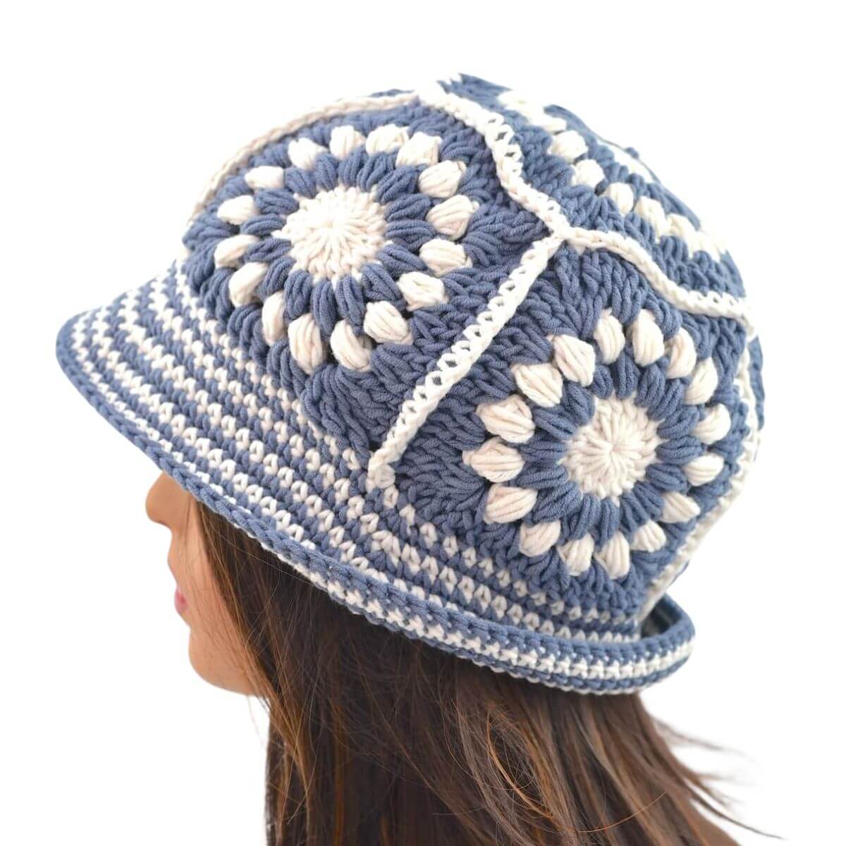Close up of slate blue and cream granny square crochet bucket hat with brim