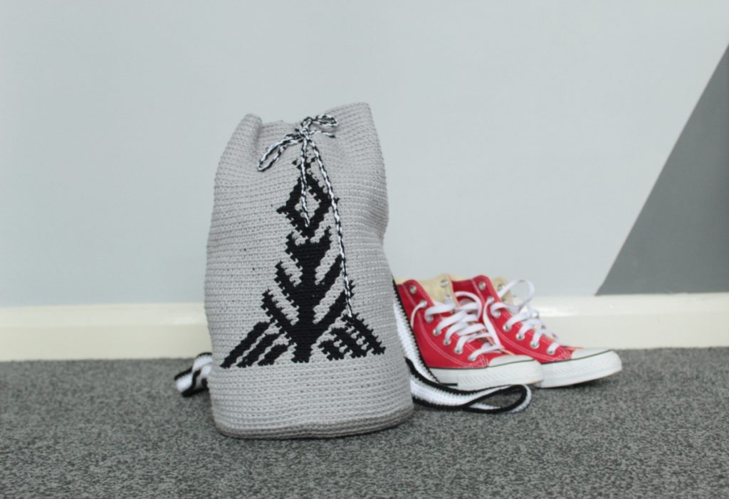 Gray drawstring crochet backpack with black tapestry tree design