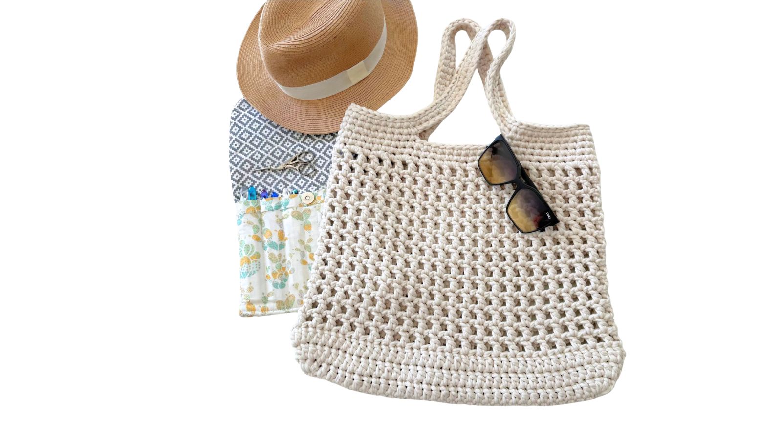Cream crochet mesh market tote bag with sunglasses and beach items