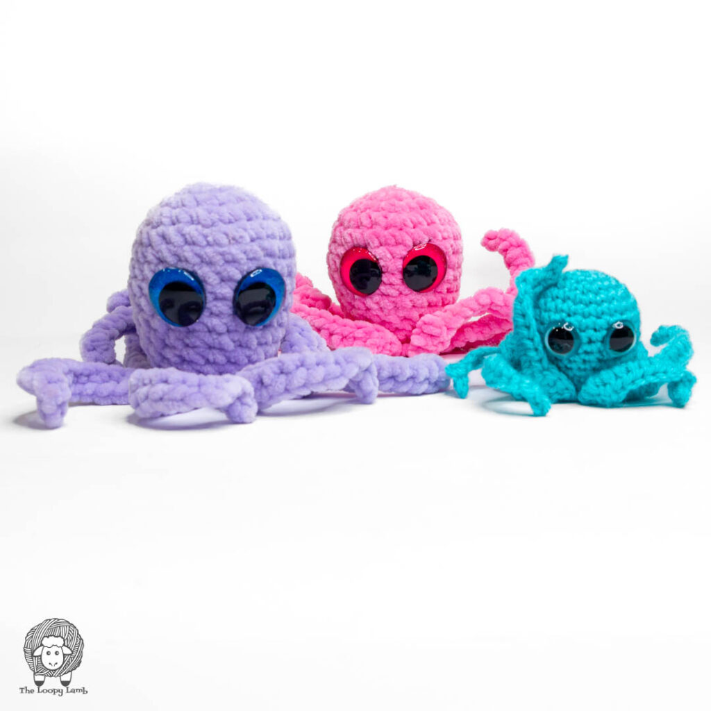 Three crochet amigurumi octopuses in purple, pink, and teal yarn