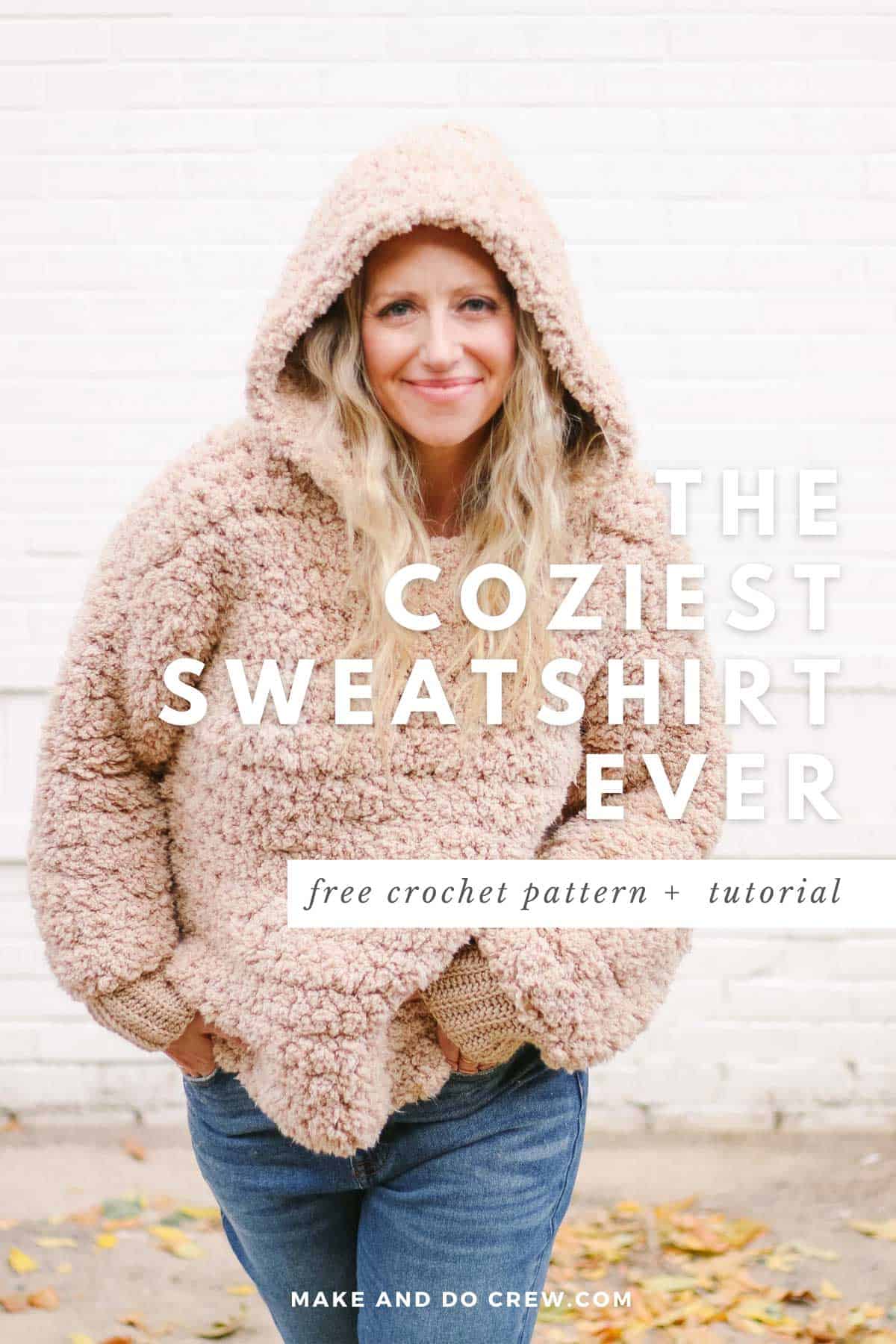 Woman wearing an oversized tan fuzzy sherpa crochet hoodie in front of a brick wall