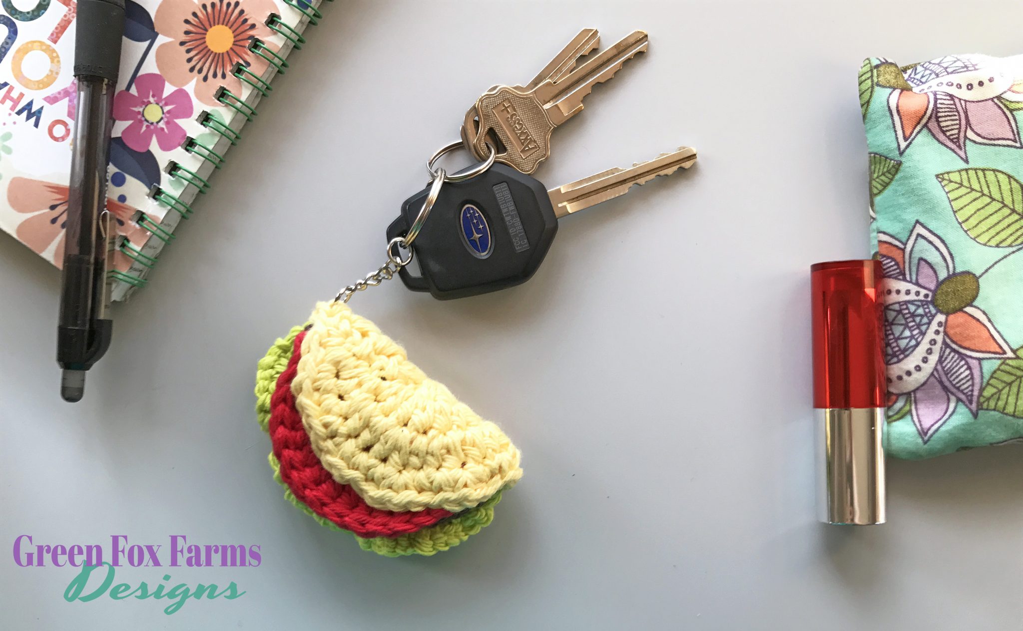 Small crochet taco keychain with lettuce and tomato attached to car keys